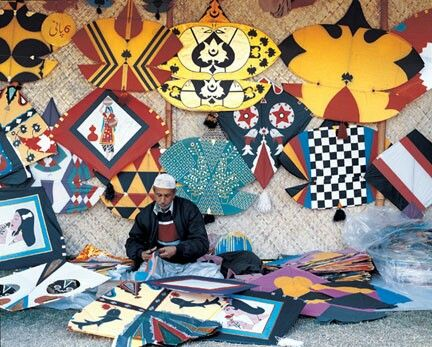 Colorful kites and string spools displayed in a busy Lahore market during Basant, highlighting Pakistan’s seasonal kite economy and small businesses