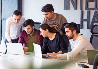 Early stage startup team in Pakistan collaborating around laptops in a modern coworking space
