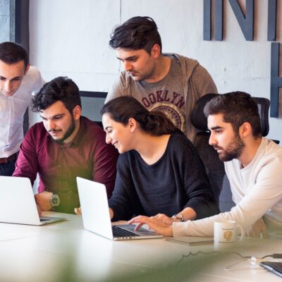 Early stage startup team in Pakistan collaborating around laptops in a modern coworking space