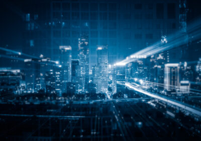 Aerial night view of a glowing city skyline with streaks of light and digital grid overlays, representing Pakistan's accelerating tech and startup ecosystem, where capital is concentrating in fintech, AI services, and cross-border ventures amid a selective post-2024 investment recovery.